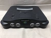 Front view of the black Nintendo 64 console with power and reset buttons visible, showing the Nintendo 64 logo and four controller ports.