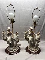 Pair of Lady Grace porcelain table lamps shown front-facing, each mounted on wooden base with brass lamp fixture, no shades attached