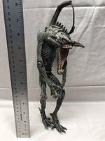 Full side profile image of the Spawn Violator III action figure with a ruler to show height approximately 12 inches
