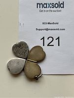 Opened locket showing four heart-shaped sections forming a clover