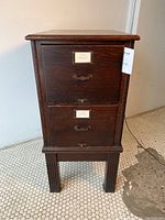 Front view showing two drawers with brass handles and label holders