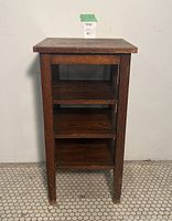 Front view showing overall construction, three shelves under flat top, and four legs.