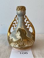 Full front view of vase showing female profile motif and gilded handles
