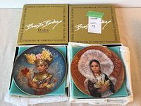 Pair of Royal Doulton Brenda Burke plates from Festival Children of the World series displayed in original boxes, showing both plates fully.
