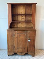 Full front view of pine cupboard showing open shelves above and closed cabinet below