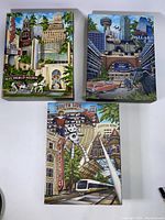 Three colorful 12x9 giclee prints arranged on white surface showing Dallas landmarks.