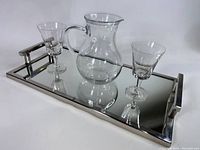 Full set on tray showing chrome mirror serving tray with glass pitcher and two glasses.