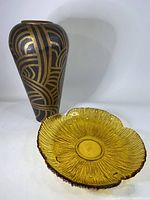 Solid hammered brass vase with black and brass geometric Indian pattern alongside amber glass flower-shaped tray.