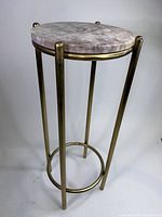 Full view of round side table with metal frame and marble top, showing overall condition and design.
