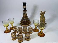 Full lot showing decanter, smaller glasses, shot glasses, and cat statue