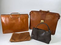 Four leather bags displayed: two medium-sized briefcases, one smaller briefcase, and one small handbag.