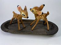 Three ceramic figurines of Disney's Bambi and Faline with a wooden tray display base, showing size and condition.