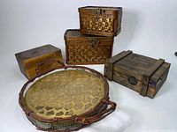 Full lot view showing five vintage baskets and boxes, including two wicker baskets with bronze latches, two wooden boxes, and one round woven tray.
