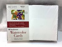 Shrink wrapped 50-pack of Strathmore Watercolor Cards with one envelope on top showing its blank white textured cold press surface and package label showing recommended paints.