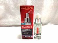 Front view of serum bottle with dropper and product box showing product name and brand.