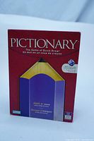 Front view of Pictionary board game box featuring large pencil graphic and game title