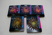 Set of five decorative magnetic lights on display cards, showing front view of flower shapes in multiple colors.