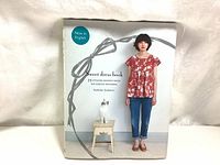 Front cover of the Sweet Dress Book showing a woman in a floral top and jeans with a cat on a stool.