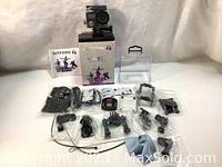 Full set of Safari 4 action camera kit with box, camera mounted in waterproof housing, and various accessories laid out on a white background.