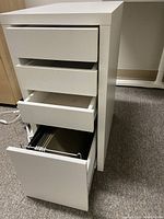 White office file cabinet with four drawers, drawers open to show metal hanging rails in bottom drawer.