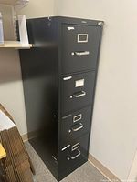 Black vertical 4-drawer file cabinet with metal handles and label holders, includes one key on top drawer lock.