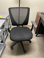 Front-facing view of the black office chair showing fabric seat, mesh back, padded armrests, and five-wheel base.