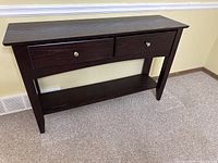 Front view showing two drawers with brushed nickel knobs and lower shelf of console table.