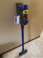 Full view of Dyson V8 Absolute vacuum on wall-mount bracket
