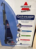 Photo of the box highlighting the Bissell Quick Steamer PowerBrush deep cleaner with product features and branding visible.