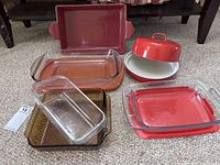 All the pans and tortilla keeper displayed on carpet. Shows sizes, colors, and lid inclusion.