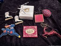 Photo of all vintage Christmas ornaments and small books together on dark fabric.