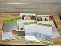 Six sealed packages of Cricut craft sheets and iron-on materials arranged on a table, showing front packaging and branding.