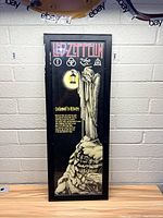 Frontal view of the Led Zeppelin wall hanging showing the full artwork including band symbols, logo, and text.
