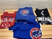 Four assorted baseball shirts including Boston Red Sox, Chicago Cubs, and Chicago White Sox, displayed folded and stacked.