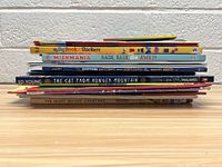 Stacked side view of 7 assorted children's books showing spines and titles.