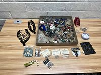 Wide shot showing the assortment of costume jewelry including bracelets, necklaces, pins, rings and earrings arranged on a table and in a box.
