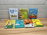 Photo showing 8 children's books by Dr. Seuss and other authors, arranged upright and flat, titles visible