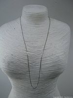 Full length view of the thin 14K gold necklace on a display bust showing the chain's lightweight and fine box chain style.
