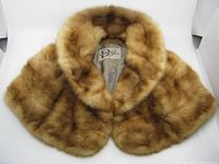 Front view of the mink stole showing plush natural brown fur with light and dark shading variations, classic stole shape with collar.