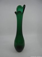 Full view of the tall, deep green swung glass vase, showing the overall shape and color.