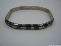 Front view of the sterling silver bangle showing malachite rectangular inlays set diagonally across the front surface.