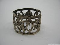 Front angle view showing cherub and floral openwork details on the napkin ring.