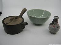 Overall view of three Chinese pottery pieces including teapot, celadon bowl, and crackle glaze vase.