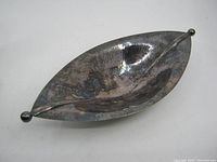 Top-down view showing the full shape and surface of the silverplate dish with visible tarnish and some wear.