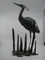 Front view of the Blue Heron metal sculpture showing the bird facing left with metal reeds on the base.
