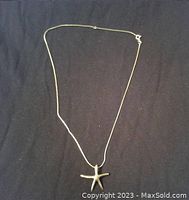 Full view of the 925 silver necklace with starfish pendant laid flat on a dark background.