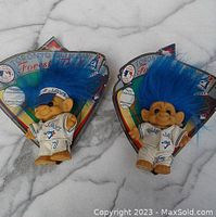 Photo showing two Toronto Blue Jays troll dolls with blue hair in original packaging labeled 1992 World Series winners