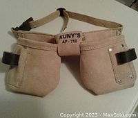 Front view of child's leather carpenter tool belt labeled KUNY'S AP-710 with two large pouches and loops