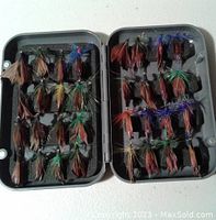 Open gray plastic case showing 36 assorted fly fishing hooks tied with feathers and synthetic materials in various colors.