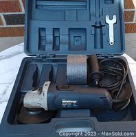 Mastercraft angle grinder placed inside carrying case with roll of grinding wheels and detachable handle.